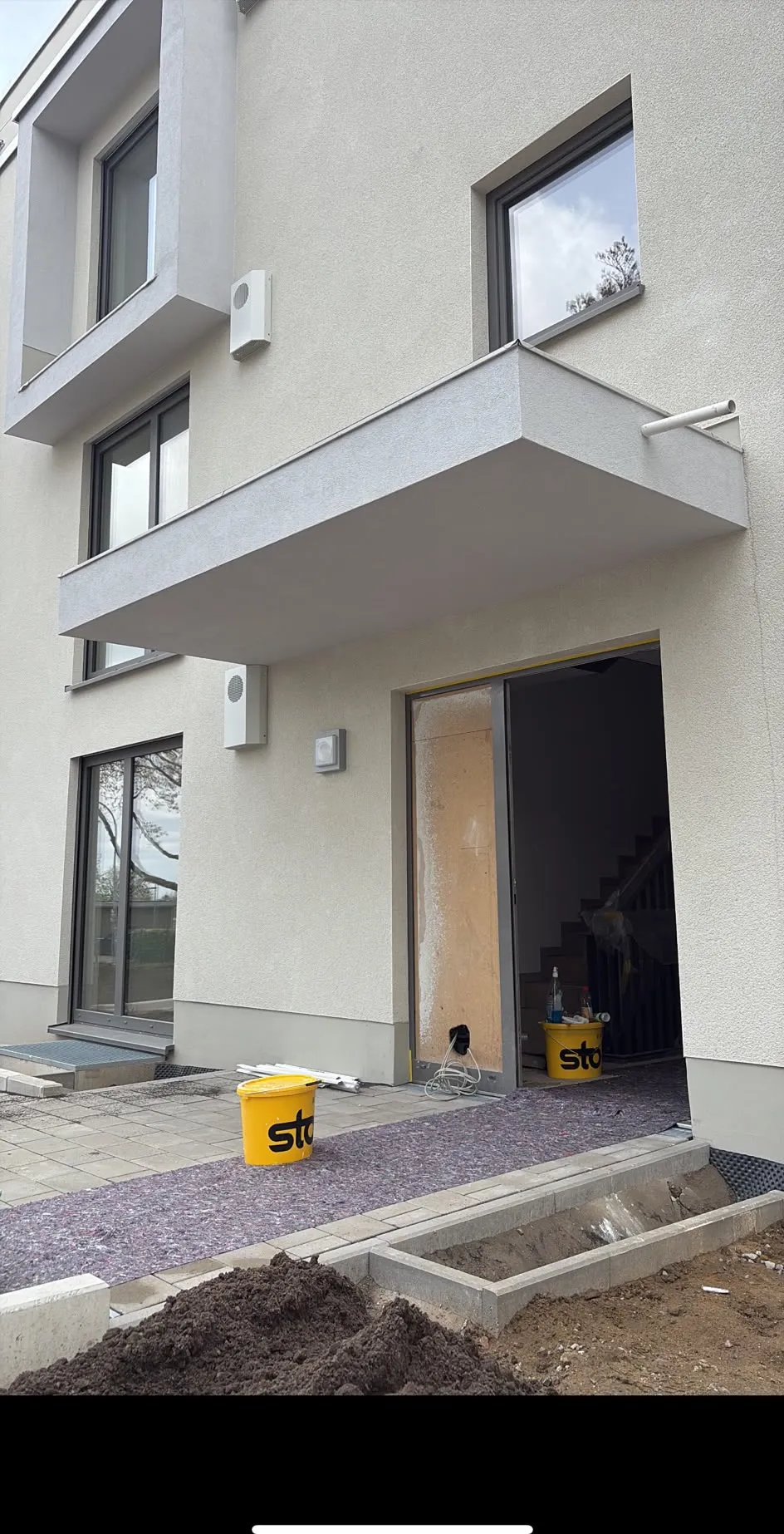 Fertige helle Putzfassade eines Neubaus mit Vordach