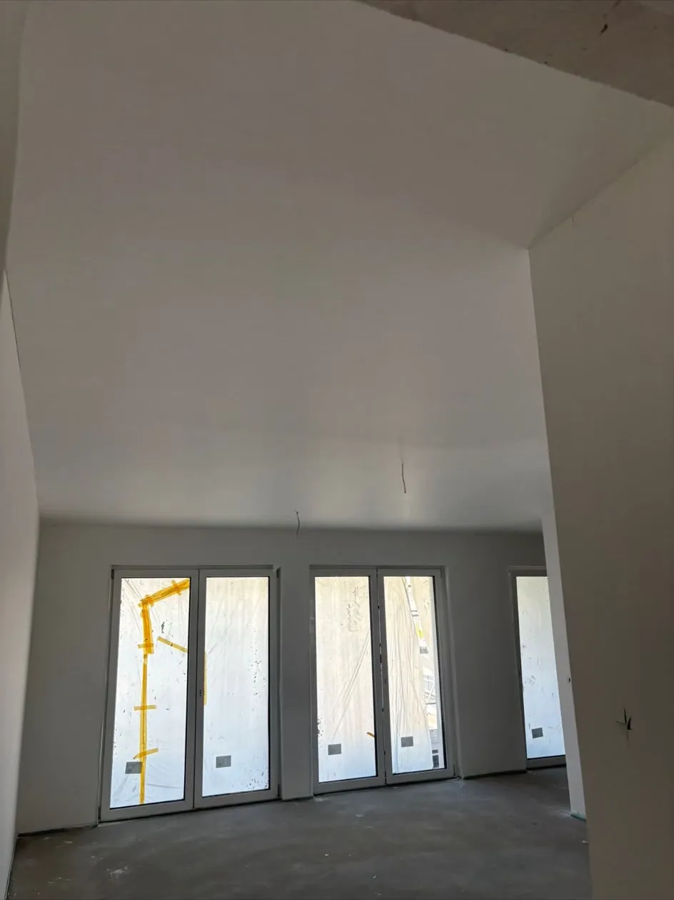 Gespachtelter Raum mit abgeklebter Fensterfront, vorbereitet für den Anstrich