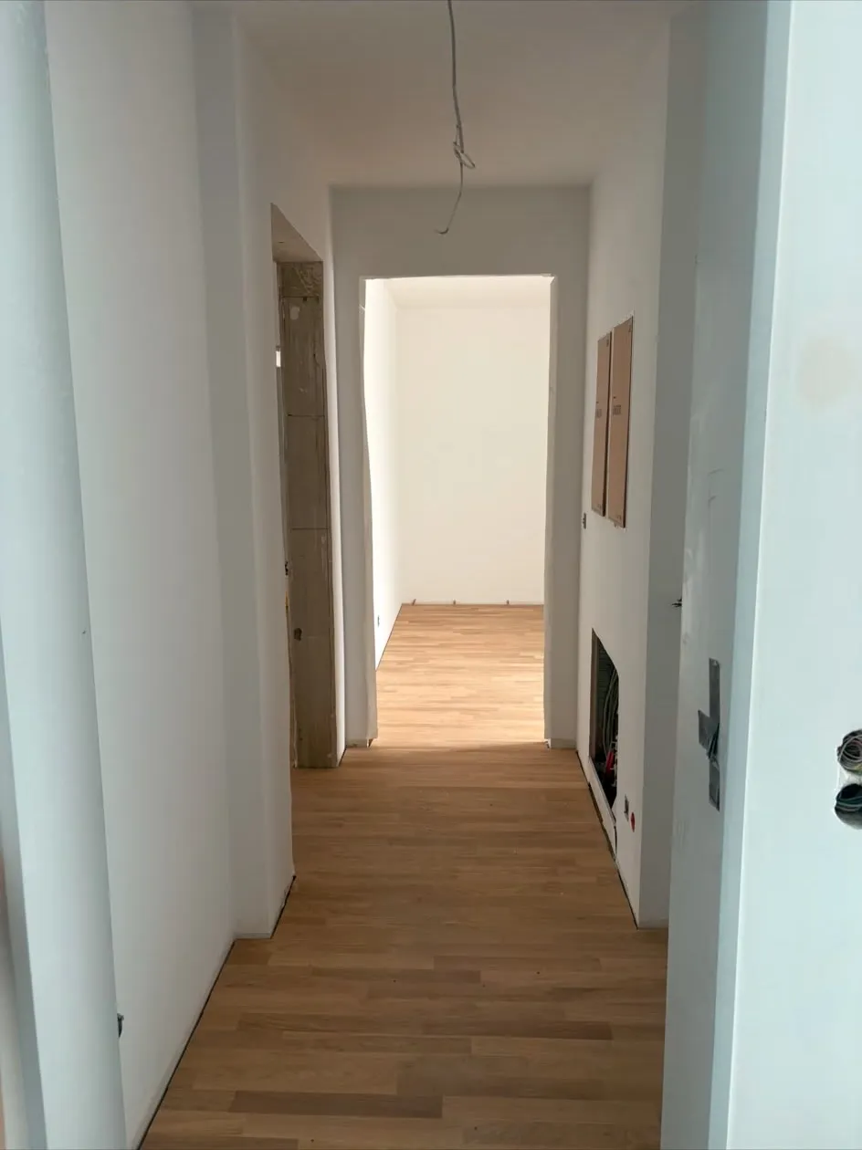 Wohnungsflur nach Abschluss der Malerarbeiten mit verlegtem Parkettboden