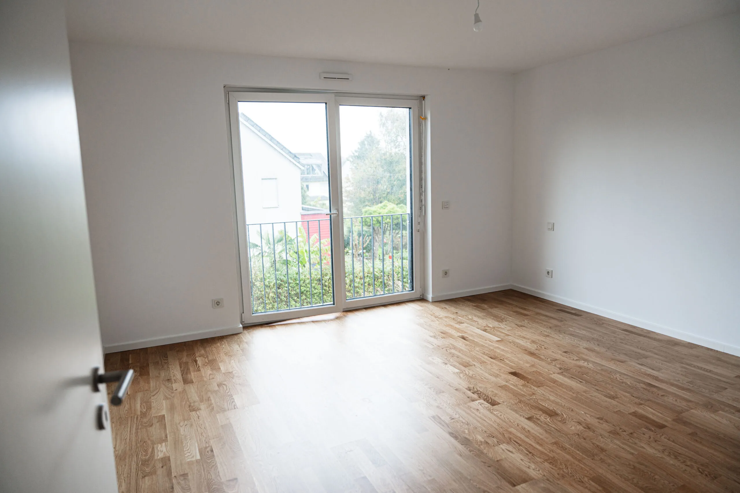 Fertig renovierter Wohnraum mit Parkett und Balkontür