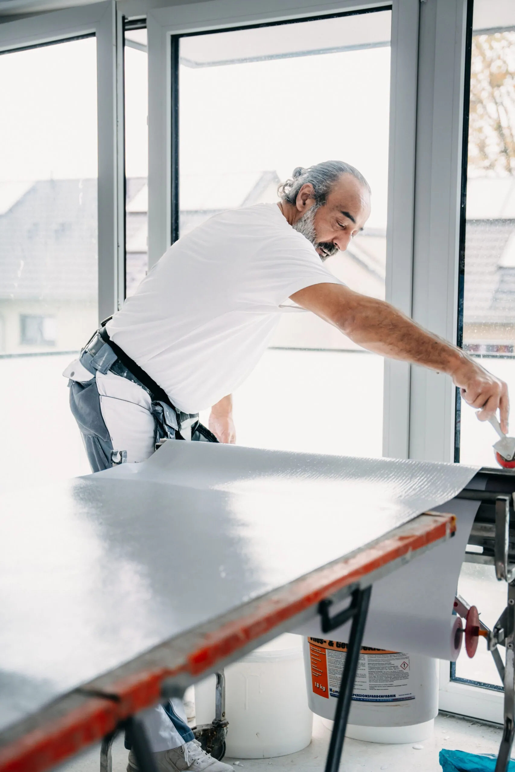 Handwerker von Alusoski beim Zuschneiden einer Trockenbauplatte