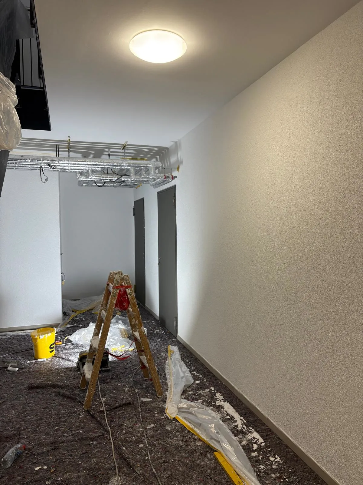 Flur mit frisch aufgezogenem Reibeputz an der Wand während der Ausführung