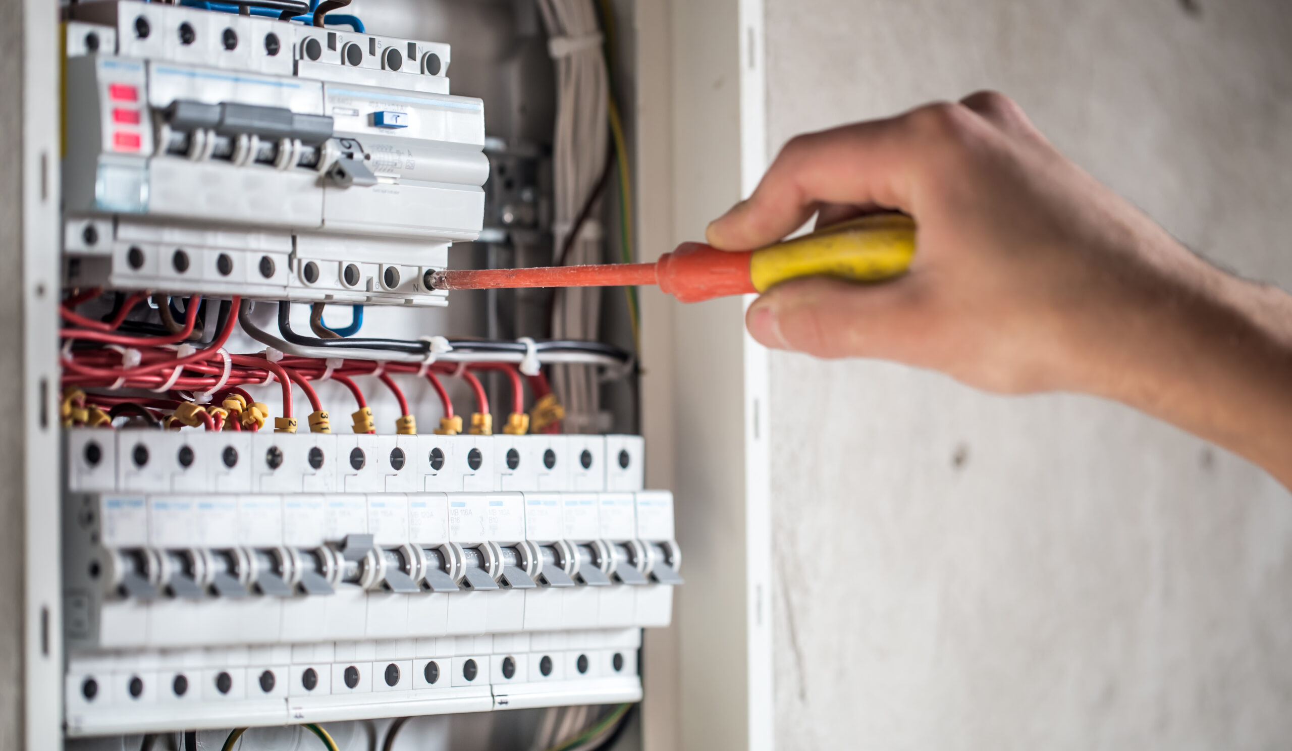 Man, an electrical technician working in a switchboard with fuses. Installation and connection of electrical equipment. Professional with tools in hand. concept of complex work, space for text. SSUCv3H4sIAAAAAAAEAI1Ry27CMBC8V+o/RD4TiZBAEv6gh0q9ox4264VYGBv50Qoh/r12jCufqt68M+vZnZ3760tVsQmsQLav7rEKtZDSW2fACa0CvF49cUOKkykR4sJpI0CW4AQOZwUXCqDyUkb4sZDMOnDeko3DnhCCo1PQSOCvRNrokOoqEwsZfgSKfZC+SmKrgrF+isy7sEhSgiLtLcv8Y/WH2Jvi0XJ08n/B9PjMvuFECm+LtcKyIUmQLB9SKzt/OzKX8gjgudCF/y+NIGNDWyhdjUChTsU37eYlj/wNtVfOxBVYtsGk1leYZAzjGDQp4zNYG9p5xotBGE6hL8Ucpd1i4KnKeMgslk27aYau23ZN0/f9sO4GlnPWeBa8tJiin0WgzK3ARdyAbVo8brEd6mbEXd0BbeqJdmO9hWHkww6xRwqHf/wA/SmPWrECAAA=